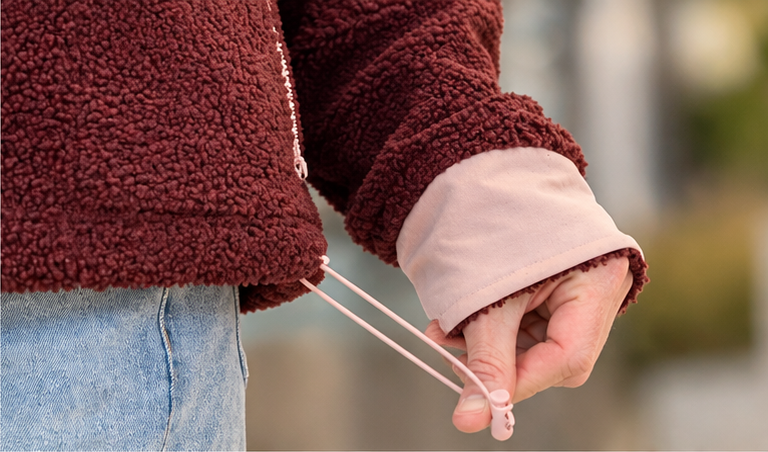 Close-up of the bungee cord and pink cuff on the SWOOP Wine Sherpa Fleece Quarter-Zip Pullover