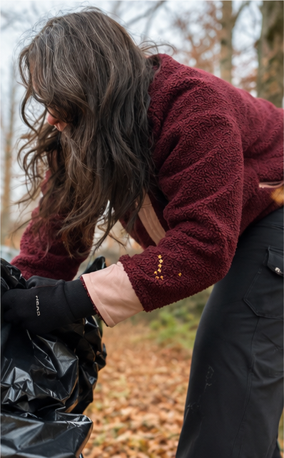 Woman raking leaves into a bag while wearing the SWOOP Wine Sherpa Fleece Quarter-Zip Pullover